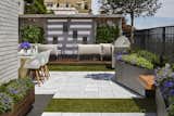 Limestone pavers and easy-to-maintain AstroTurf recreate the feel of a country patio underfoot right in one of the busiest cities in the world.