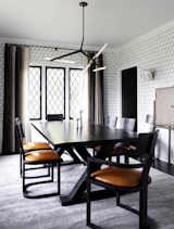 A chandelier by Lindsey Adelman hangs over a dining room with geometric accents.