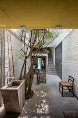 Architect Toan Nghiem of a21 Studio designed the Saigon House to merge Ho Chi Minh City’s typical architectural and stylistic details. Native trees are planted on the ground floor as well as on balconies and in the steel frames, covering the home with plants and bringing a piece of the natural world inside. A rear alleyway in the joint family home serves as a living and dining room, while an overhead netted area offers a playground for the children.