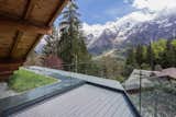 Outdoor, Small Patio, Porch, Deck, and Wood Patio, Porch, Deck Glass walls fence in an outdoor deck without obstructing spectacular views of the mountains and valley.  Search “outdoorpatio,-porch,-deck--wood” from A Mountain Hideaway Plants a Green Roof in the French Alps