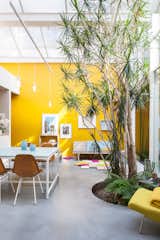 Furnished with vintage Eames chairs, a second-hand sofa, and pendants and tables designed by Nathalie, the space is kept purposefully casual. She painstakingly mixed and tested the paint for the mustard-yellow walls herself—15 times—to match the hue of a Kvadrat textile.