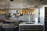 Kitchen, Range, and Undermount Sink Floating brass shelves fabricated by local sculptor Gilad Ben-Artzi contrast the steel wall.  Photo 18 of 121 in KITCHENS by Trey McCampbell from Steel and Brass Cover Nearly Every Surface of This Industrial L.A. Kitchen