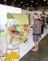 A visitor tries out the Osmose swinging bed from Fermob.