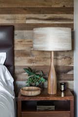 A vintage wood lamp and turned bowl stands next to the bed. "We wanted to incorporate elements used in residential homes," Hollis says of the eclectic medley of accessories and furnishings in the space. "These would be items that you would collect over time. They don't exactly match, but they all work together—they create a relaxed casual environment while still elevating the interior and amenities to what you expect from a world-class luxury property."