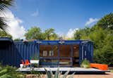 While shopping for containers, the resident of this San Antonio shipping container home was instantly drawn to this one’s existing blue color and chose to buy it and leave it as is. The architect added floor-to-ceiling sliding doors to allow light in, as well as a cantilevered overhang to shade a window on the left side, which houses a small garden storage area.