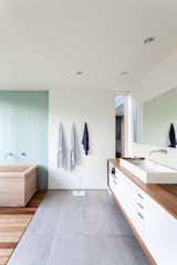 The owners were passionately involved in every aspect of the design, and pushed the team to make choices they normally might not have, including using Western red cedar for the master bathroom countertop. The spa-like space features a soaking tub, tile from Statements Urban, an MTI sink, a custom mirror, and a Vola faucet.