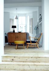 Furniture throughout the house echoes the soft materiality of the architectural details, which include original pine floorboards refinished with lye and wood soap. The music room armchair and footstool are vintage, from Ercol; the blue-gray Grasshopper floor lamp is by Greta Grossman from Gubi.
