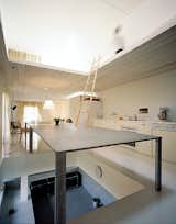 This image best illustrates the ambiguous spatial relationships in the home. The black slab acts as a mezzanine as well as a place to eat and gather.  Photo 4 of 8 in Great Modern Interiors in Japan by Erika Heet