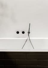 Fixtures by Naoto Fukasawa for Aboutwater, a collaboration between Boffi and Fantini, adorn the Villeroy & Boch tub.  Photo 9 of 12 in We Can’t Get Enough of This German Apartment’s Sleek Matte-Black Kitchen
