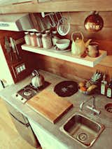 Herbert fashioned the custom kitchen countertop from a foam-core backer board, which he coated with a concrete microtopping. The wood is clear-grain cedar.