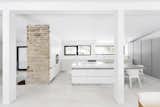 Neutral colors and streamlined appliances like the Miele oven, stovetop, and refrigerator, along with the Espace Cuisine cabinets, create an elevated interior.