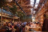 The interior of the restaurant at Mercat de Santa Caterina showcases the building's soaring roof line, massive beams, abundant natural light and near-floor-to-ceiling wood shelving.