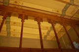 A shot of the ceiling showcases the room's original and restored decorative elements, from the hand-painted ceiling to the ornate columns that delineate space. Montenar, a contemporary of Antoni Gaudi, was actually the more popular architect for commercial commissions during their shared heyday.