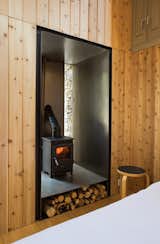 To heat their renovated home in southwestern France that formerly functioned as an old mill built in 1822,  Blee Halligan Architects installed a 17.75-inch-tall, 15.75-inch-wide, and 15.75-inch-deep wood-burning stove equipped with a built-in water boiler. The stove was built into an old doorway that was no longer needed, and elevated on a metal platform that incorporated firewood storage horizontally below the fireplace.