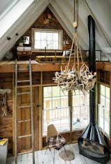 The interior of a treehouse at the camp features a wood-burning stove and antler chandelier.&nbsp;