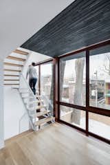 Staircase, Wood Tread, and Metal Railing The addition creates a narrow intermediary space between the yard and existing home. This sliver contains a staircase and two new sun rooms.  Photos from A City Home Grows Without Gobbling Up its Garden