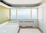 Upstairs, the bedrooms are arranged in a uniform line of five cubicles. Initially, each bedroom had a vividly colored western wall—red, blue, yellow, or green—with the remaining three walls painted white.  Photo 7 of 9 in Bauhaus by the Sea