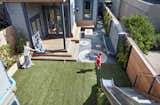 A pebble mosaic and artificial turf divide the yard into zones that never need to be mowed.
