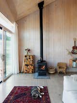 A woodburning stove keeps the 820-square foot interior of this off-grid home in eastern Washington state by Jesse Garlick. The True North wodo stove from Pacific Energy is fed firewood stored in the stacked wood cabinets adjacent.