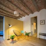 The partition separating the bedroom from the living room appears to be a partial wall—but in reality, a mirror extends from the top of the wall to the ceiling.  Photo 5 of 6 in In Barcelona, Vaulted Ceilings Are Always a Win