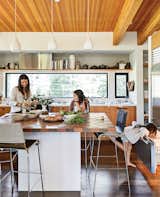 In the kitchen, designer Maca Huneeus prepares lunch with her daughters Ema, 12, and Ofelia, 7. The pendants are Jonathan Adler; the island is a custom design, inspired by a 1960s Dansk tray that belonged to Huneeus’s mother. The barstools are from Blu Dot.