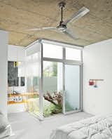 The guest room occupies the least favorable corner of the house, so Paredes designed an interior garden featuring driftwood combed from the beach to give the space something special. An American Standard sink and Hansgrohe faucet rest atop a custom vanity.