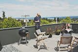 Rex folding rocker chairs from Design Within Reach are paired with black galvanized-steel planters from Ikea on the building’s roof deck.