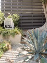 An Egg swing from Patricia Urquiola’s Maia collection for Kettal sits in the garden.
