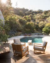 Low retaining walls form a subtle barrier between the backyard and the surrounding vegetation. Mandy Graham designed the armchairs and lounges.