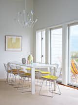 A Single Octopus chandelier by Autoban hangs above a Four dining table by Ferruccio Laviani for Kartell and a set of side chairs by Harry Bertoia for Knoll.