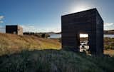 Before building on the North Island of New Zealand, two friends spent years replanting the site. The 290-square-foot structures that Cheshire Architects designed for them reject the local trend of oversized beach houses. Instead, they sit on the landscape like a pair of minimalist sculptures.