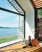 Windows, Metal, and Picture Window Type The Trues host parties in the glass-walled structure, located steps from their vacation home, or they escape to it to catch some rays and read a book. Bill reclines on cushions hidden under the reclaimed-fir floorboards that are propped up with Sugatsune hinges.  Photo 6 of 12 in Interiors by Victoria beatriz lara from Outdoor