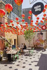 Spice Alley's four outdoor eateries enliven the laneway under a canopy of red lanterns. "Resurrected building frontages spill out onto the street and provide a streetscape that is activated by day and night by conversation, creative hustle, and culture," says landscape architect Mike Horne of Turf Design Studio.