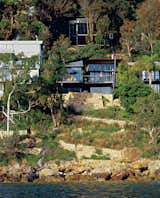 Outdoor, Slope, Trees, Shrubs, and Boulders Set high on a cliff along the south end of the beach, this residence of three glass-and-copper pavilions offers a mighty reward for conquering the steep ascent.  Outdoor Slope Trees Photos from Three Glass-and-Copper Pavilions Conquer the Cliffs