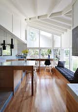 The architects used blackbutt wood for the flooring and Whisper White paint by Dulux throughout the interior. An A110 Hand Grenade Pendant Lamp, by Alvar Aalto for Artek, hangs above the white Carrara marble-topped island.