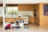 The appliances are by Miele, and the sink and faucet are by Blanco. In the dining area, a Link Suspension lamp by LZF hangs above the Minotti table and chairs. The artwork is by Nathan Coley.