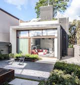 In the rear of the house, a new addition extends the living space and adds a roof terrace off the second-floor master bedroom. A garden is accessible through a wall of sliding glass doors with Sapele mahogany frames, set back to control solar gain.