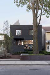 The transformed facade features dark gray stained-masonry.  Photo 12 of 13 in A 1930s Tudor Home Brightens Up in Toronto
