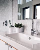 Passive House bathroom white drop-in sink and stainless steel silver faucet.
