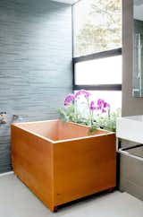 Charred House bathroom with wood atandalone tub and flowers 