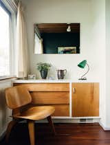Built-in details include a dresser that pairs with an Eames molded plywood lounge chair in a guest bedroom.