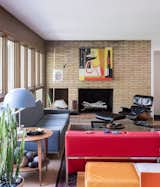 In the living room, a vintage Paul McCobb sofa, a Gio Ponti side table, and an Eames lounge echo the home’s midcentury architecture—as does the thrifted red Florence Knoll Parallel Bar sofa that lends the room a shot of color.