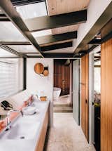 Bath Room and Freestanding Tub Fung + Blatt designed the master bathroom vanity, which features Agape washbasins and fixtures and an angled mirror that reflects the oak trees seen through the skylights.  Photo 5 of 14 in Creative Revival of a Modernist Gem