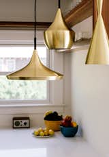 Brass pendants by Tom Dixon hang in the kitchen.