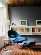 A walnut-topped table and Womb chair, both by Eero Saarinen for Knoll, offer a cozy spot for reading.