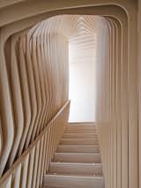 To breathe new life into a historic brick home, architect Nader Tehrani of NADAAA used precision-cut plywood for the interiors and two sculptural staircases with an undulating grotto effect.  