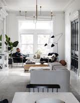 Jason lounges in one of two armchairs by midcentury designer Milo Baughman in the parlor-floor living room. The wood block coffee table is by Eric Slayton, a friend of the couple, and the modular Carmo sofa is from BoConcept. A 1952 piece by French industrial designer Serge Mouille, the Three-Arm Floor Lamp—widely referred to as the "Praying Mantis," for its looming trio of arms—is a nod to the couple’s love of Parisian interiors; a branch-like chandelier by Los Angeles–based artist Gary Chapman hangs overhead.