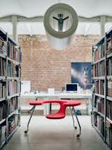 Office, Library Room Type, Shelves, Desk, and Chair Recalling the form of an airplane engine, his cylindrical D2V2 pendant hovers above his sculptural Easy Rider, a mobile desk-seat hybrid set on castors.  McWhorter Vallee Design Inc.’s Saves from Futuristic Forms Meet Historical Details in Designer Danny Venlet's Brussels Home
