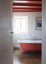 Pinch-Bannon Residence bathroom with sliding windows and orange painted ceilings with exposed beams.