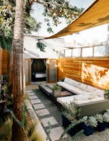 A wicker sectional from Target and a custom fire table that Todd designed sit under Sunbrella shade sails.  Photo 1 of 95 in favoritos by susana belo from This Backyard Triumphs Over Trouble to Become an Oasis of Calm